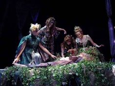 three women dressed as fairy tale characters sitting on a bed with ivy growing around them