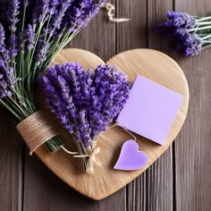 lavender flowers on a heart shaped wooden board with a notepad and string tied to it