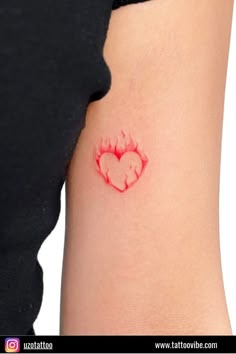 a woman's arm with a heart shaped tattoo on the left side of her body