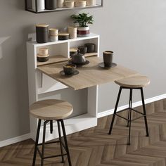 two stools sit in front of a table with cups on it