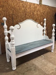 a white bench sitting in front of a wall with wood paneling on the side