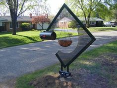 a metal sculpture in the shape of an upside down hammock hanging from it's side