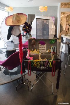 a table with some hats on top of it and other items in the back ground