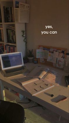 a laptop computer sitting on top of a wooden desk next to a book shelf filled with books