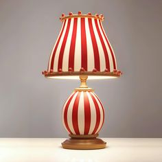 a red and white striped lamp sitting on top of a table