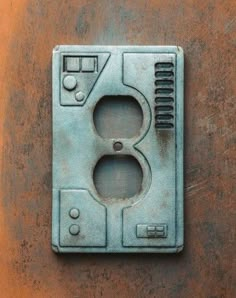 an electrical outlet cover on the side of a metal wall mounted device with two outlets