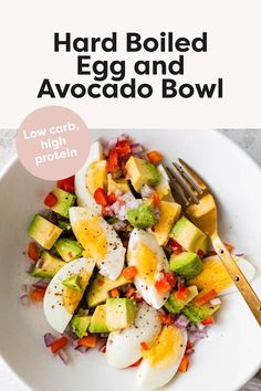 an egg salad with avocado, tomatoes and onions in a white bowl next to a fork