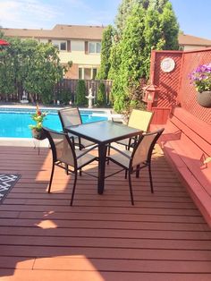 a table and chairs on a deck next to a swimming pool