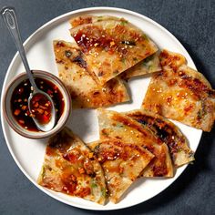 a white plate topped with food and dipping sauce