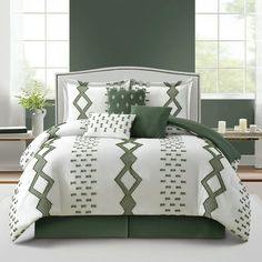 a bed with green and white comforters in a room