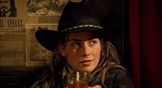 a man wearing a cowboy hat holding a drink