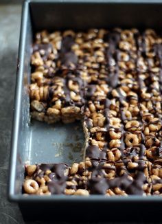 chocolate and cereal bars in a baking pan with one missing from the cookie bar, ready to be eaten