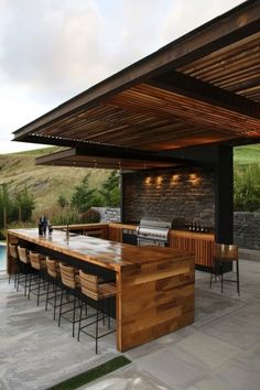 an outdoor kitchen and dining area next to a pool