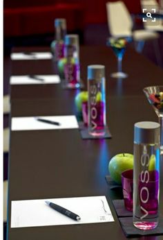 the table is set up with wine glasses and fruit