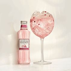 a pink drink in a glass next to a bottle on a white table with the words best low cal cocktails