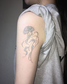 a woman's arm with a tattoo on it that has a jellyfish in the water