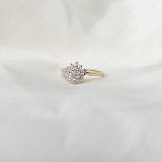 a diamond ring sitting on top of a white cloth