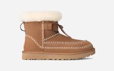 Please join us in welcoming the newest addition to our Classic family: the Classic Mini Alpine. Steeped in UGG® Heritage, this boot features iconic details like our signature Twin Seam, exposed sheepskin collar, and fixed leather lace. The suede upper and ultralight on-the-foot feel deliver the familiar UGG® experience you know, love, and crave. | Suede upper. Decorative stitching, UGG®braid pull tab, Suede mudguard. Fixed leather lace. 17mm Sheepskin collar lining, 17mm UGG®plush 60% upcycled w Ugg Mini, Ugg Classic Mini, Decorative Stitching, Sneaker Slippers, Ugg Classic, Classic Boots, Slipper Sandals, Slides Shoes, Classic Mini