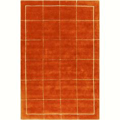 an orange area rug with squares and lines on the top, in front of a white background