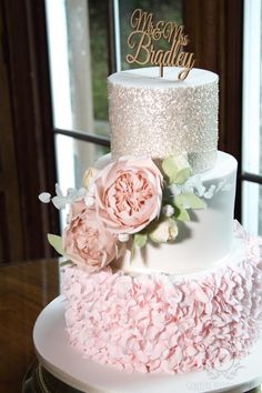 a three tiered wedding cake with pink flowers on top