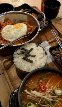 several bowls of food on a table with rice, beans and other foods in them