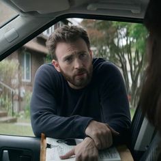 a man sitting in the back seat of a car looking at something on his hand