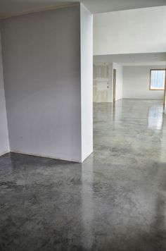 an empty room with concrete floors and white walls