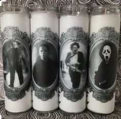 three candles with pictures of people on them in front of a black and white background