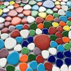 multicolored glass pebbles are arranged on the floor in this mosaic tile pattern, which is very colorful