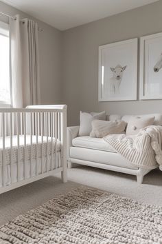 a baby's room with a white crib and two pictures on the wall