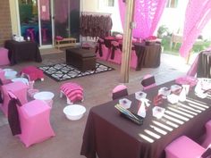 a room filled with tables covered in pink and black cloths