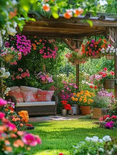 an outdoor area with flowers and couches in the middle, surrounded by greenery