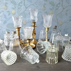 many different glass vases and candlesticks on a table