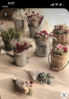 several buckets filled with flowers sitting on top of a table