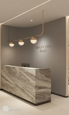 the front desk of a beauty salon with lights hanging from it's ceiling and marble counter top