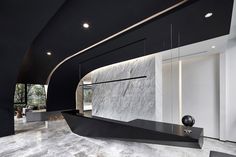 an elegant black and white living room with marble walls, flooring and ceiling lighting