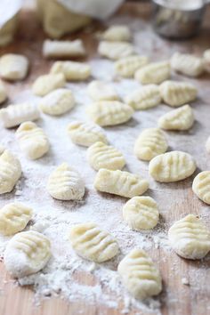 doughnuts are being made on a wooden board with flour scattered around the edges