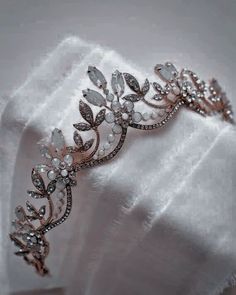 a close up of a white cloth with a gold and crystal tiara on it