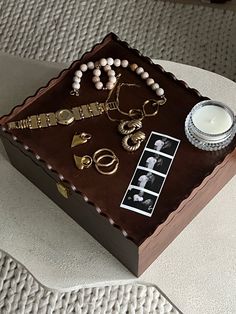 a cake with jewelry on it sitting on top of a table next to a candle