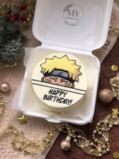 a birthday cake in a box with a cartoon character on the front and happy birthday written on it