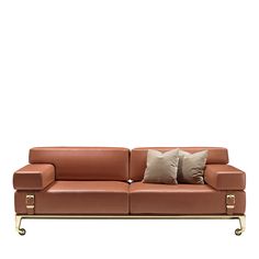 a brown leather couch with two pillows on it's back and one arm extended