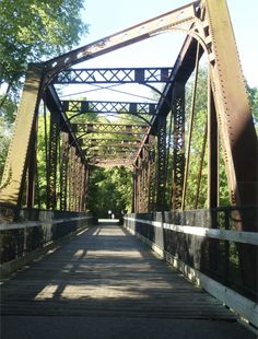 an old metal bridge with trees in the background