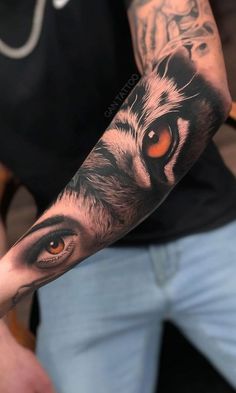 a man's arm with an orange eye and tiger tattoo on the upper half of his arm