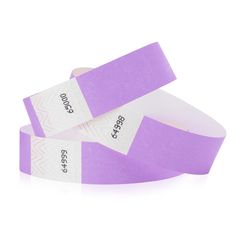 two purple wristbands with white labels on them