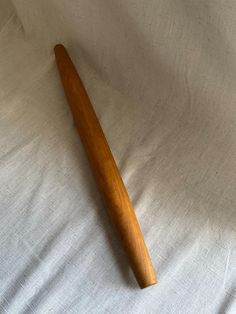 a wooden baseball bat laying on top of a white sheet