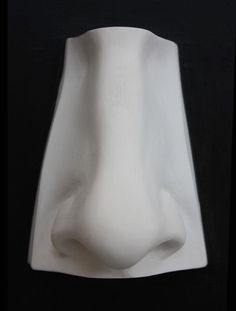 a white vase sitting on top of a black table