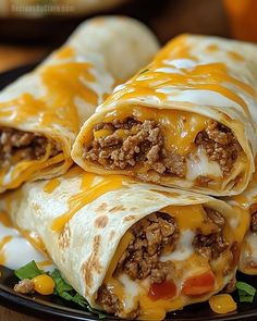 two burritos on a plate with cheese and meat