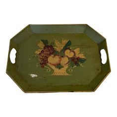 an old green tray with fruit painted on the front and sides, sitting on a white surface