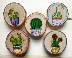 four painted wooden slices with cactus and succulents on them