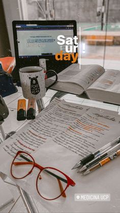 an open book on a table next to a laptop computer and some reading glasses with the words sattur day written in front of it